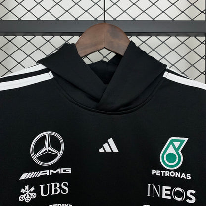 Black Mercedes-AMG Petronas F1 hoodie with sponsor logos, displayed on hanger from revnhaus
