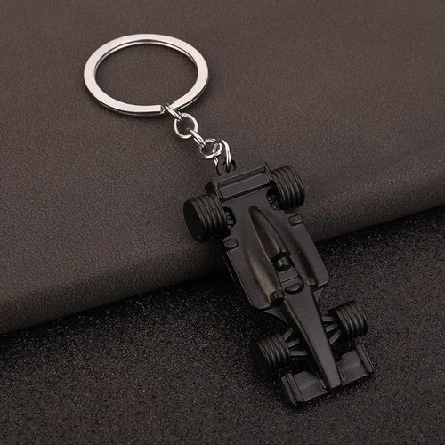 Black F1 race car keychain with silver ring, motorsport collectible from revnhaus