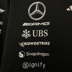 Black motorsport jacket with Mercedes-AMG, UBS, CrowdStrike, Snapdragon, and Signify logos from revnhaus