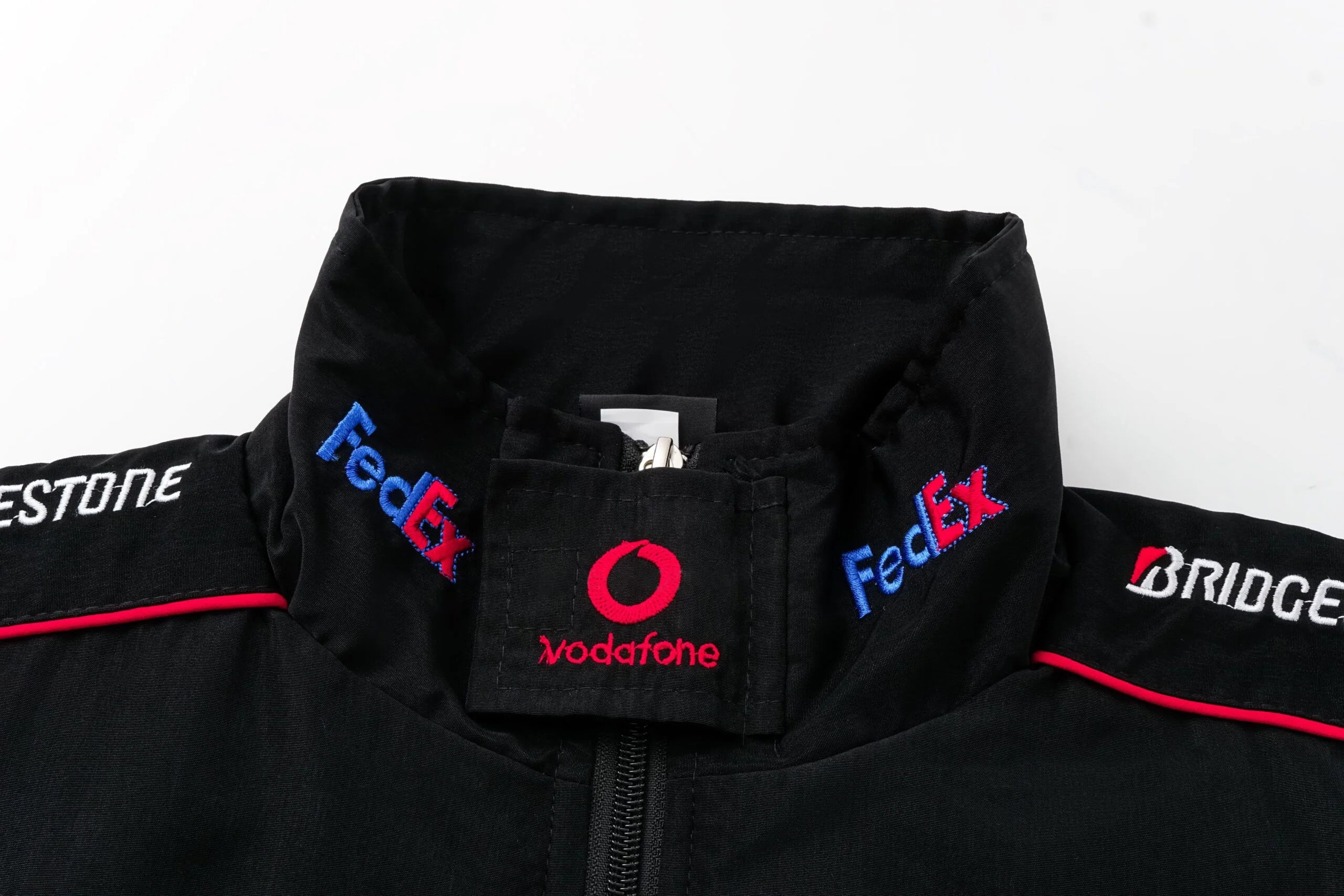 Black F1 racing jacket with FedEx, Vodafone, Bridgestone logos from revnhaus