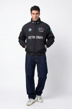 Men's BMW M Power Petronas racing jacket with blue accents, worn with jeans and sneakers from revnhaus
