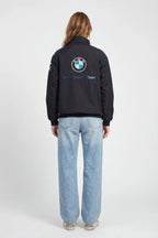 Black BMW Sauber F1 Team jacket with logo, worn with light denim jeans from revnhaus