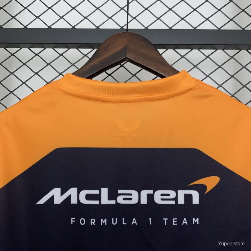 McLaren Formula 1 Team racing t-shirt in orange and navy, displayed on hanger from revnhaus