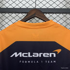 McLaren Formula 1 Team racing t-shirt in orange and navy, displayed on hanger from revnhaus