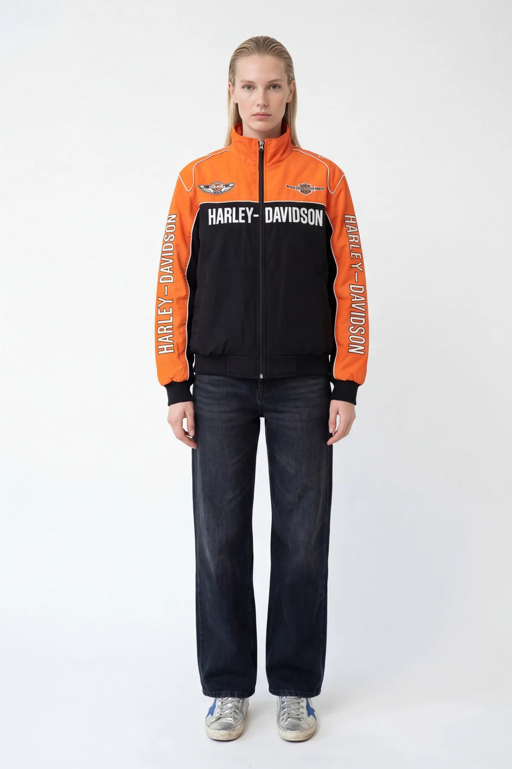 Orange and black Harley-Davidson racing jacket with bold branding, styled with jeans and sneakers from revnhaus