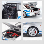 Silver Nissan Skyline GT-R die-cast model with blue stripes, detailed interior, engine, and rear spoiler from revnhaus