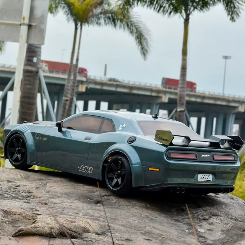 Green RC drift car with SRT styling parked on rock near palm trees and bridge from revnhaus