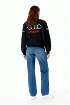 Black Audi Sport racing jacket with logo, worn with jeans and white sneakers from revnhaus