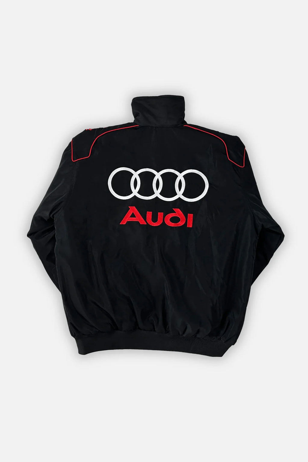 Black Audi racing jacket with white rings and red logo, motorsport apparel from revnhaus