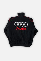Black Audi racing jacket with white rings and red logo, motorsport apparel from revnhaus