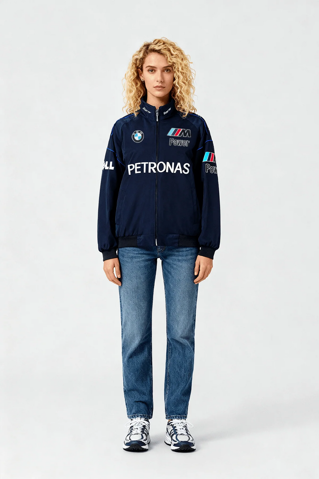 Woman wearing navy BMW M Power Petronas racing jacket with jeans and sneakers from revnhaus