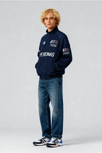 Man wearing navy BMW M Power Petronas racing jacket with jeans and sneakers from revnhaus