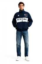 Men's navy BMW M Power racing jacket with Petronas logo, paired with jeans and white sneakers from revnhaus