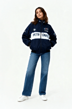 Woman in navy BMW M Power Petronas racing jacket and jeans from revnhaus