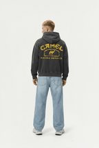 Black hoodie with vintage Camel Racing Service graphic, worn with blue jeans from revnhaus