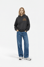 Black racing hoodie with Camel Racing Service logo, styled with wide-leg jeans and sneakers from revnhaus