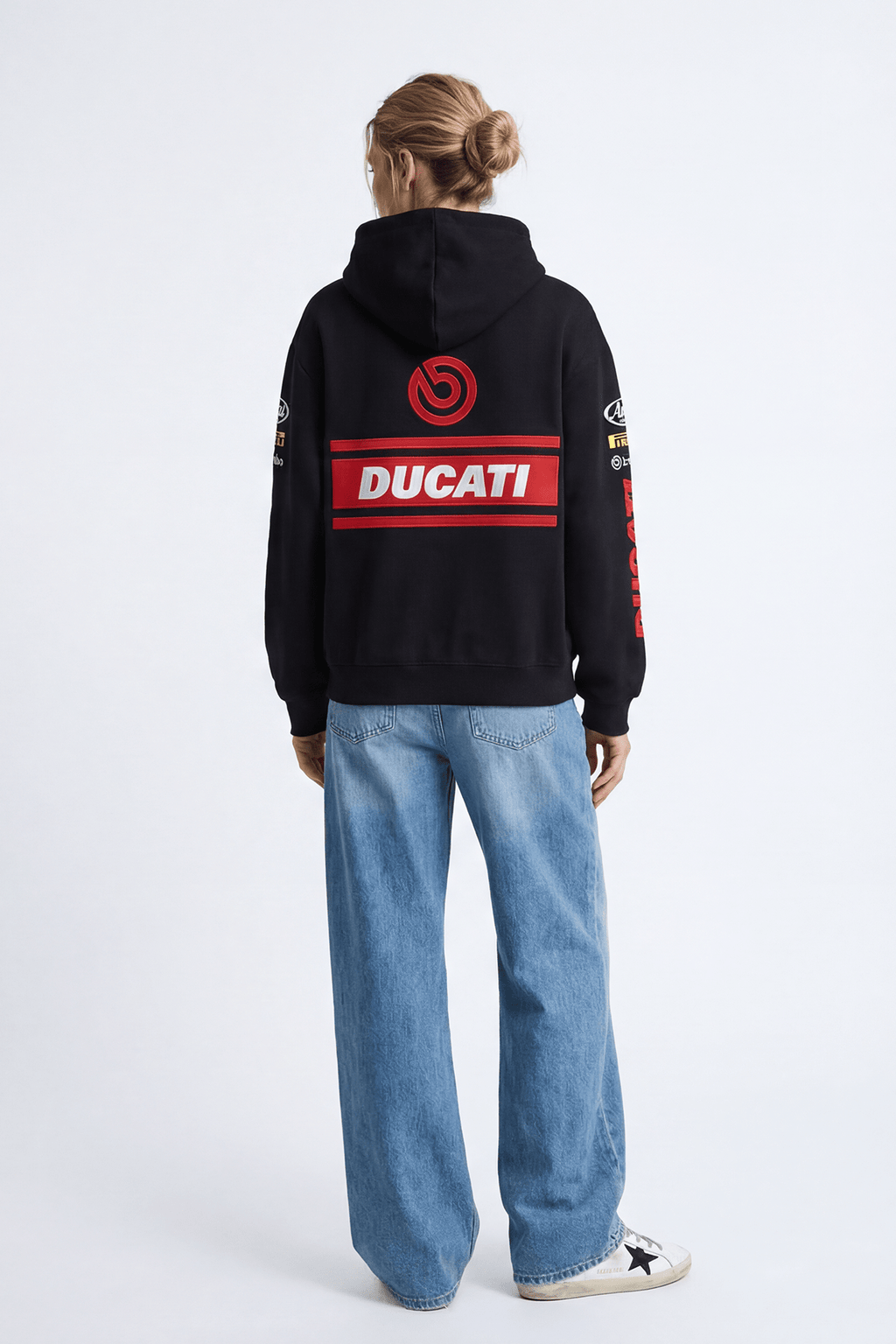 Black Ducati racing hoodie with red logo and sponsor patches, worn with jeans from revnhaus