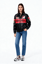 Black Ferrari racing jacket with red accents and sponsor logos, worn with jeans and sneakers from revnhaus