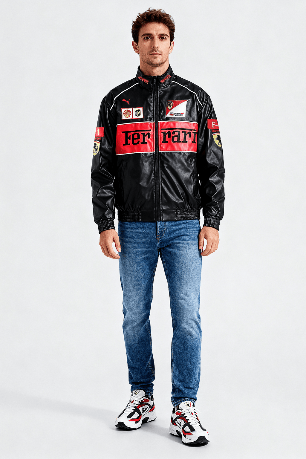 Men's black Ferrari racing jacket with red accents and sponsor logos, paired with jeans and sneakers from revnhaus