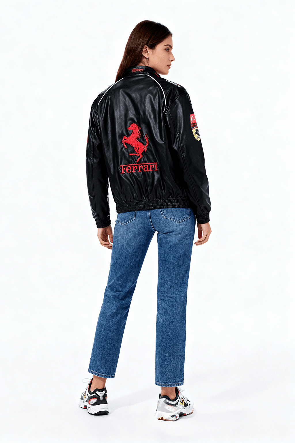 Black Ferrari racing jacket with red prancing horse logo, worn by woman in jeans from revnhaus