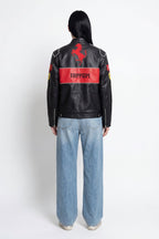 Black Ferrari racing jacket with red prancing horse logo and stripe, worn with jeans from revnhaus