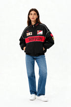 Black Ferrari racing jacket with red stripe, Puma logo, and sponsor patches, worn with blue jeans from revnhaus