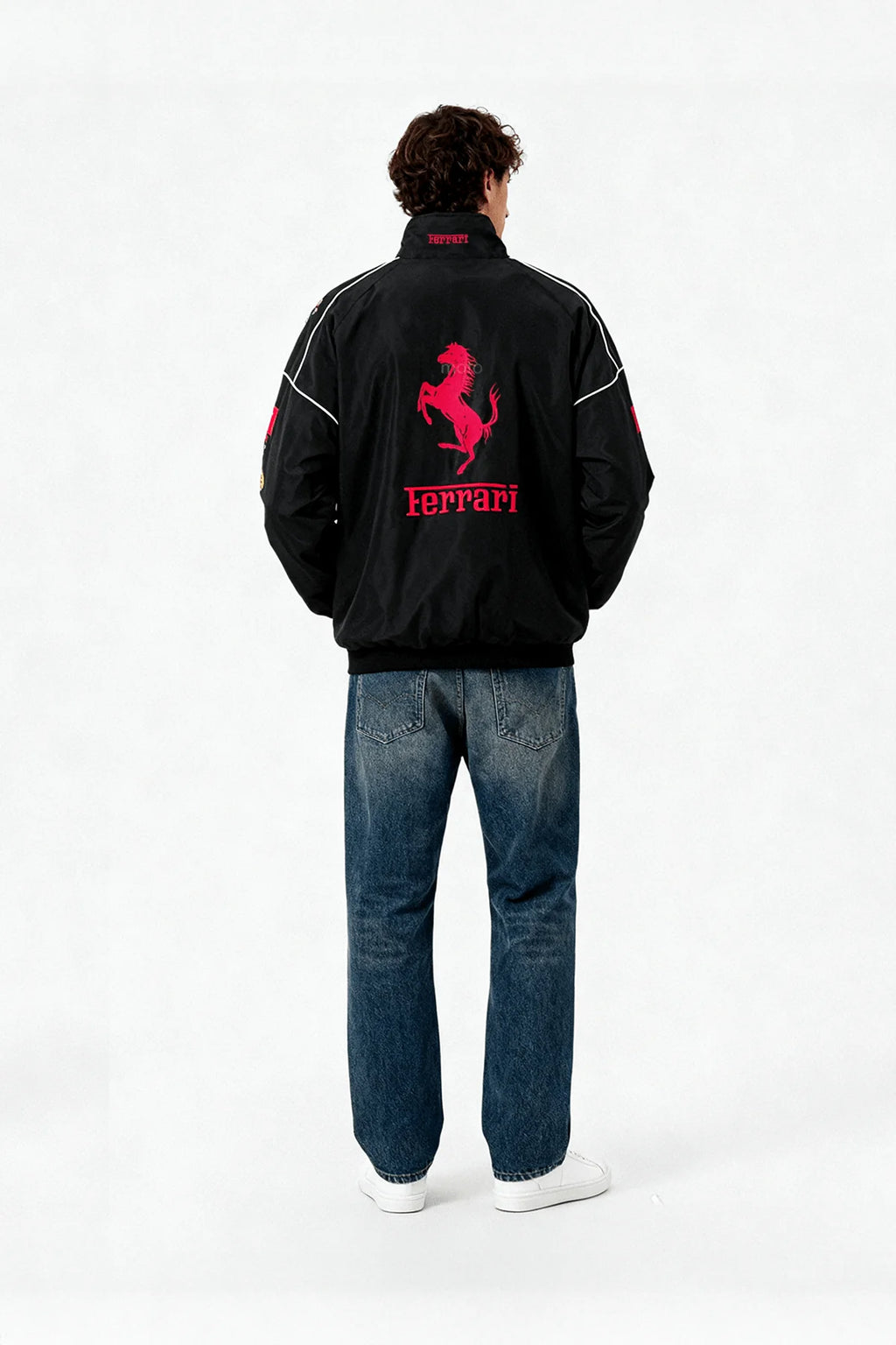 Black Ferrari racing jacket with red prancing horse logo, worn with jeans from revnhaus