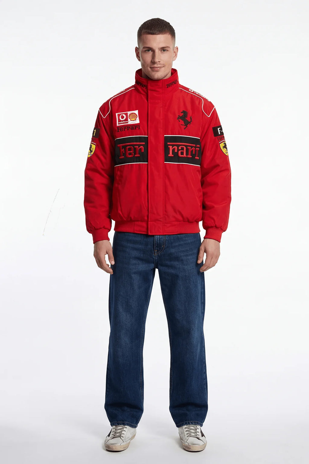 Red Ferrari racing jacket with sponsor logos, worn with jeans and sneakers from revnhaus