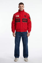 Red Ferrari racing jacket with sponsor logos, worn with jeans and sneakers from revnhaus