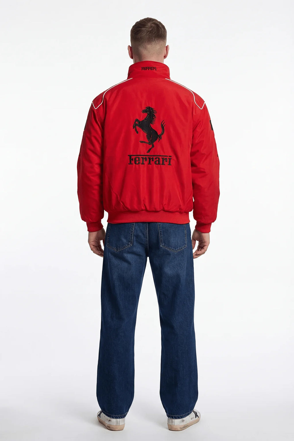 Red Ferrari racing jacket with black prancing horse logo on back, worn with jeans from revnhaus