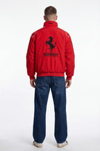 Red Ferrari racing jacket with black prancing horse logo on back, worn with jeans from revnhaus