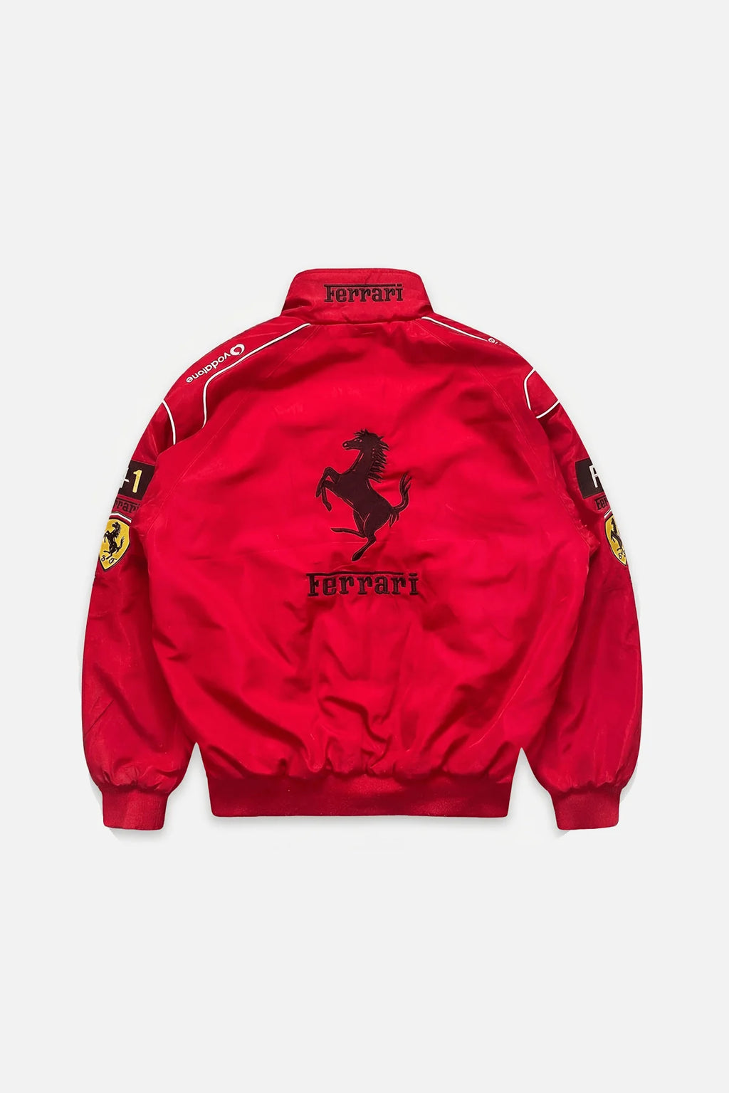 Red Ferrari racing jacket with prancing horse logo and sponsor patches from revnhaus