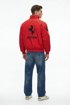 Red Ferrari racing jacket with prancing horse logo, worn with jeans from revnhaus