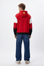Red Ferrari hoodie with embroidered logo and color-block sleeves, worn with jeans from revnhaus