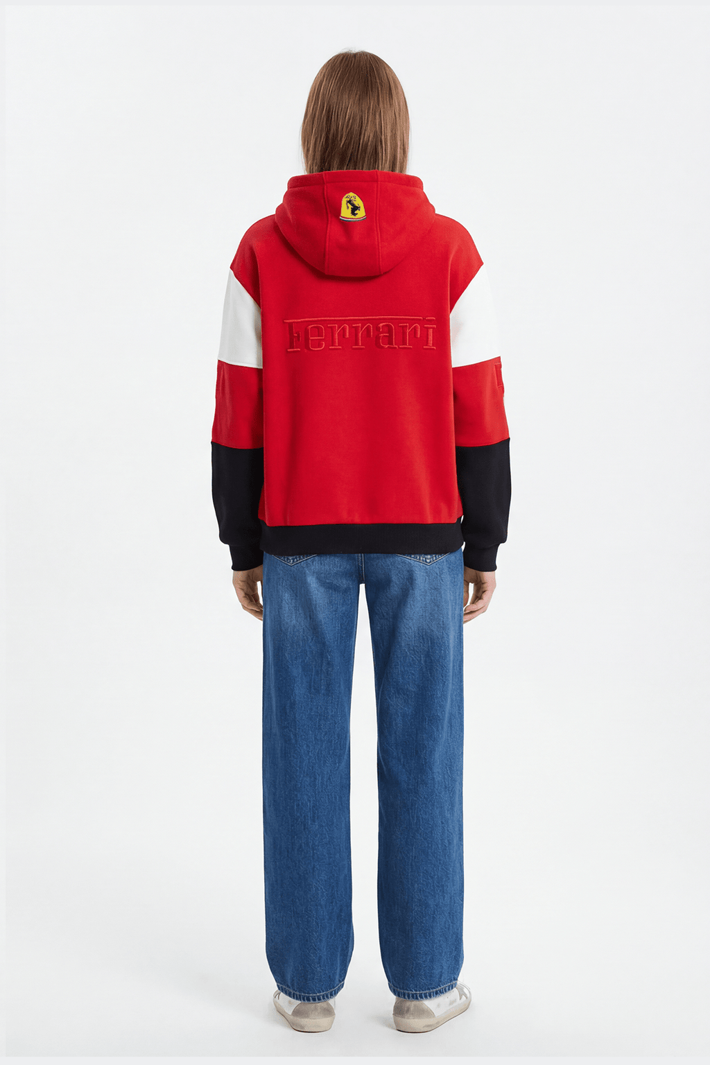 Red Ferrari hoodie with embroidered logo and color-block sleeves, worn with jeans from revnhaus