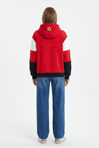 Red Ferrari hoodie with embroidered logo and color-block sleeves, worn with jeans from revnhaus