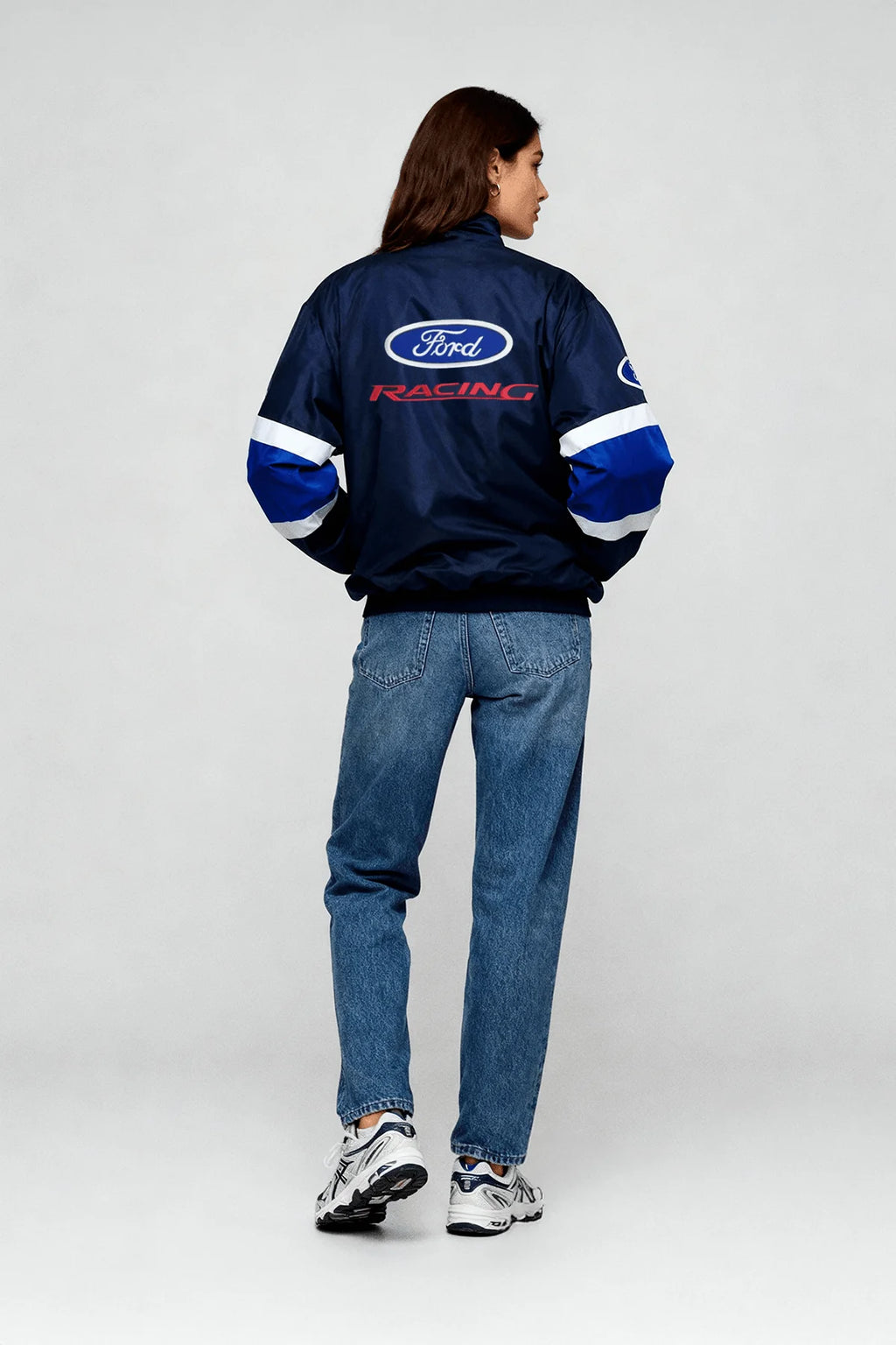 Ford Racing bomber jacket with blue and white stripes, worn by woman in jeans from revnhaus