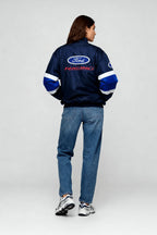 Ford Racing bomber jacket with blue and white stripes, worn by woman in jeans from revnhaus