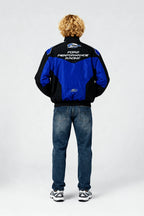 Blue and black Ford Performance Racing jacket worn by model, back view from revnhaus