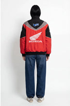 Red Honda racing jacket with white wing logo and GAS patch, worn by model from revnhaus