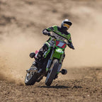 RC drift bike racing on dirt track with Fox gear, kicking up dust from revnhaus