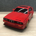 Red BMW E30 M3 die-cast model car with gold wheels and DATES decal from revnhaus