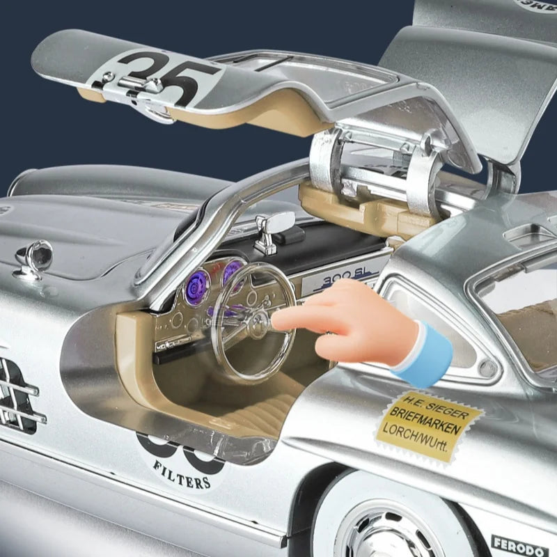 Silver Mercedes-Benz 300 SL die-cast model with open gullwing door, detailed interior, and racing decals from revnhaus