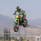 RC motocross rider mid-air on green dirt bike with Fox gear from revnhaus