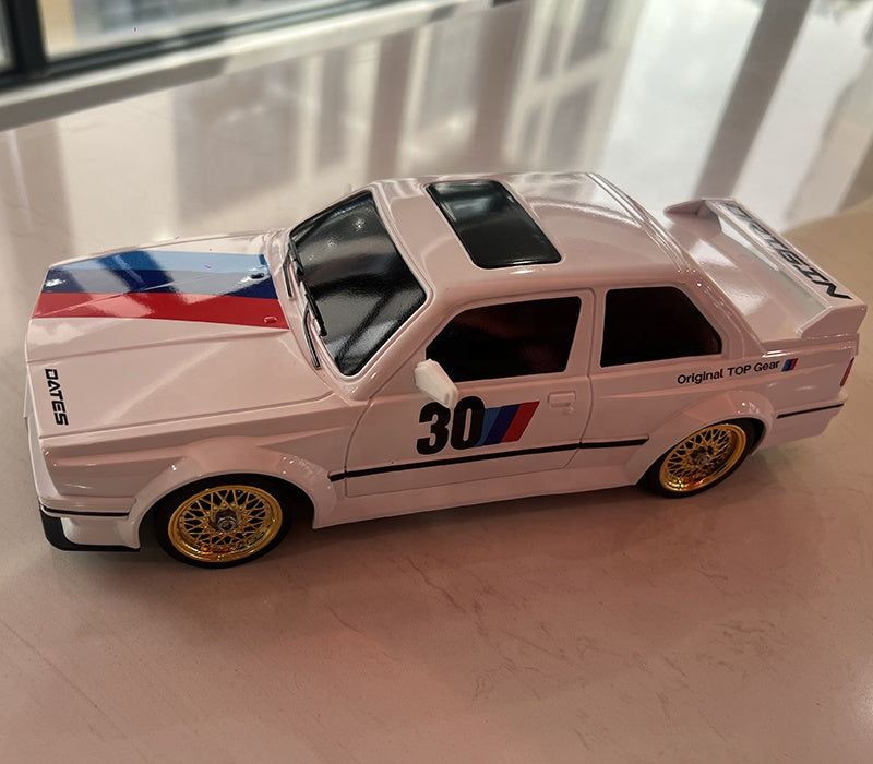 White BMW M3 die-cast model with gold wheels, racing stripes, and #30 livery from revnhaus