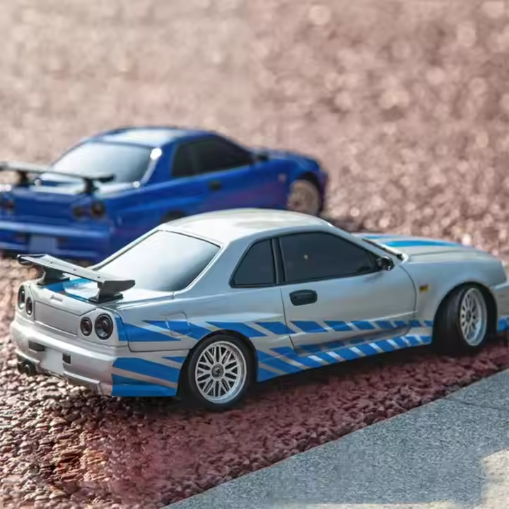 Silver and blue RC drift car with racing stripes on gravel, from revnhaus
