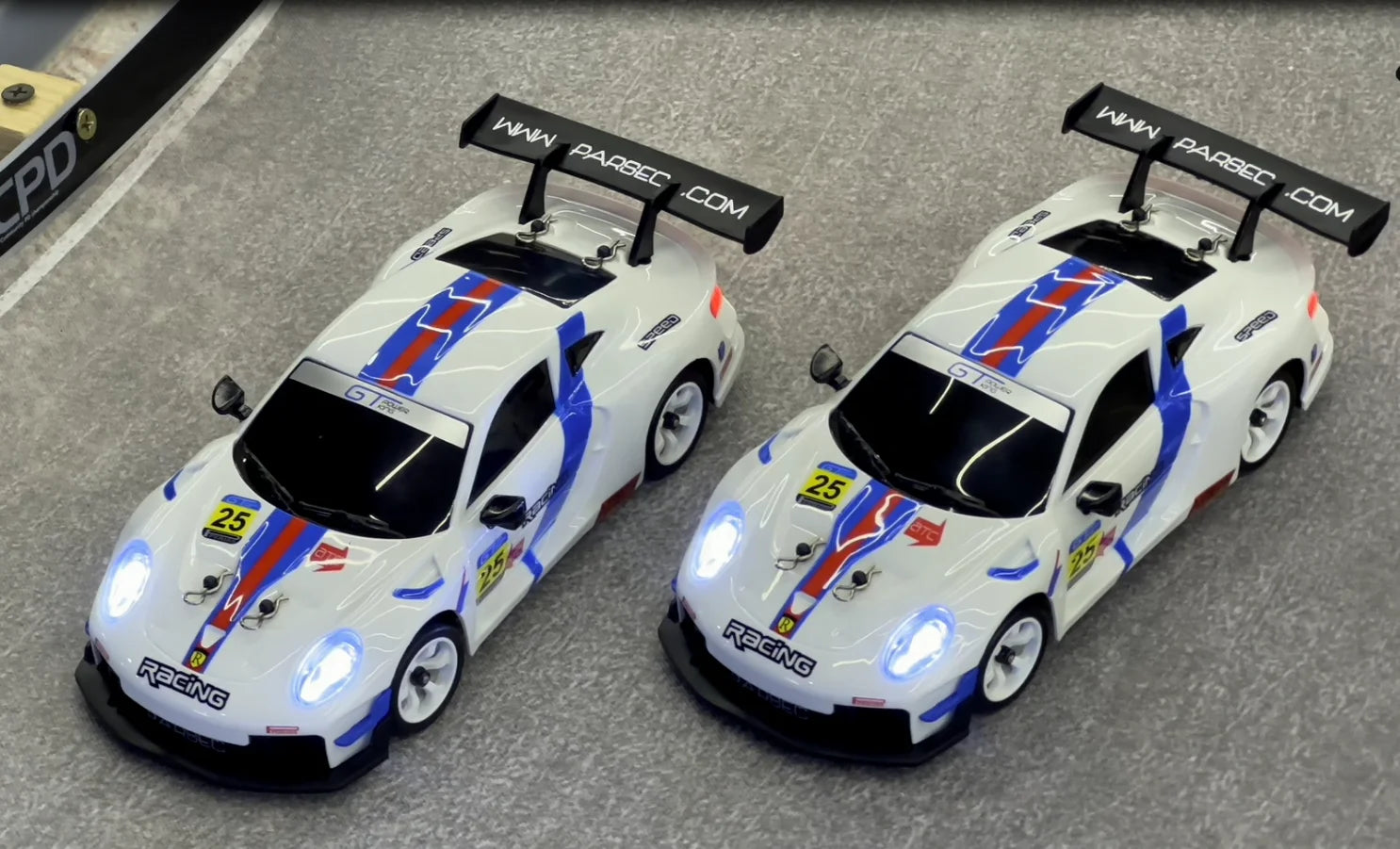 White RC drift cars with blue red stripes, LED lights, and racing decals from revnhaus