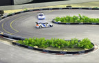 RC drift cars racing on a detailed track with RCPD barriers and greenery from revnhaus