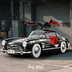 Black Mercedes-Benz 300 SL with gullwing doors open, red interior, vintage racing decals from revnhaus