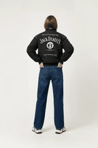 Black Jack Daniel's racing jacket with bold logo, worn with jeans and sneakers from revnhaus